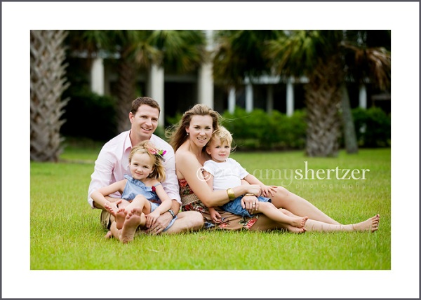 A family relaxes in the grass for their portrait session.